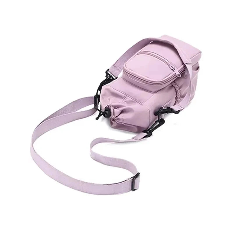 Light purple CarrySling bag laid flat, angled view showing extended adjustable strap and front pocket
