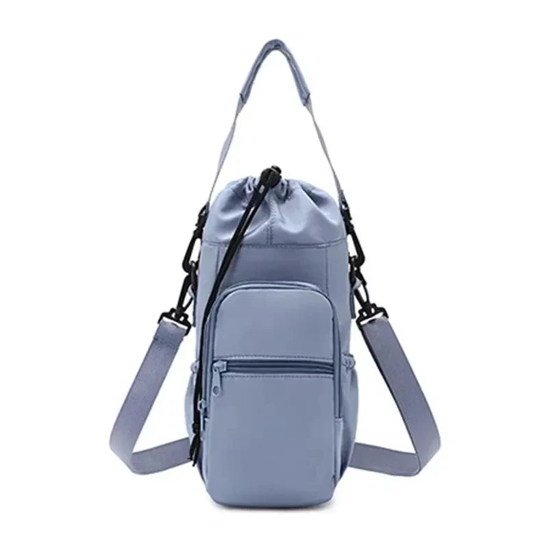 Blue-gray CarrySling bottle carrier bag with adjustable strap, front zipper pocket, and drawstring top