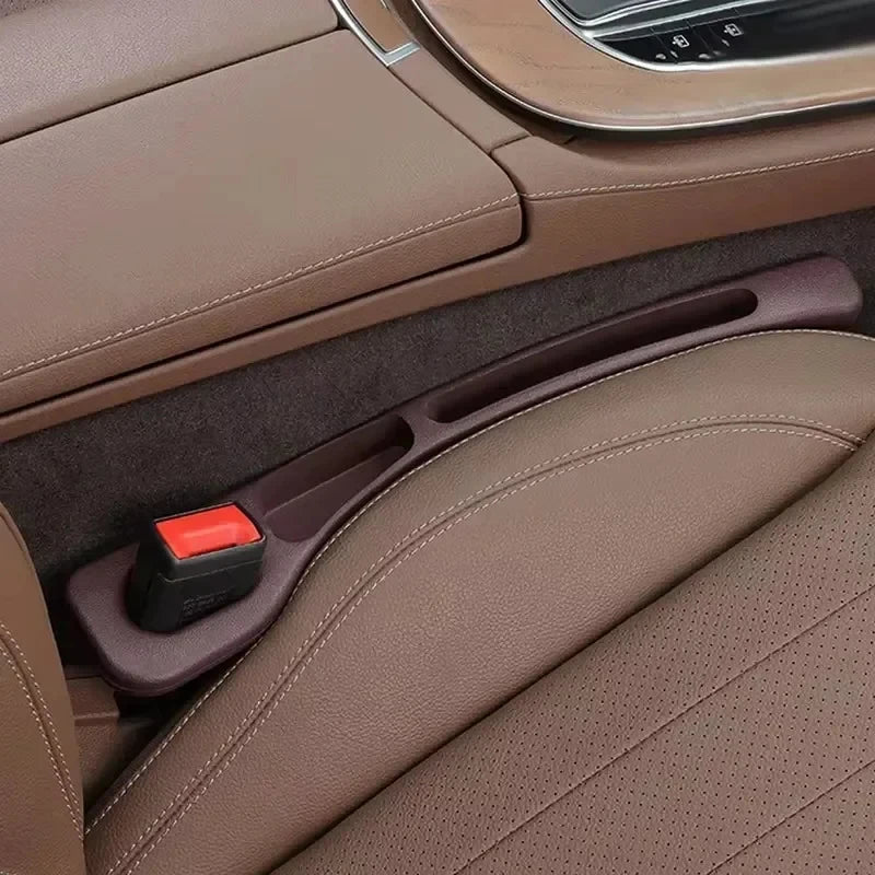 Close-up of GapGuard installed in tan leather seat gap with red buckle