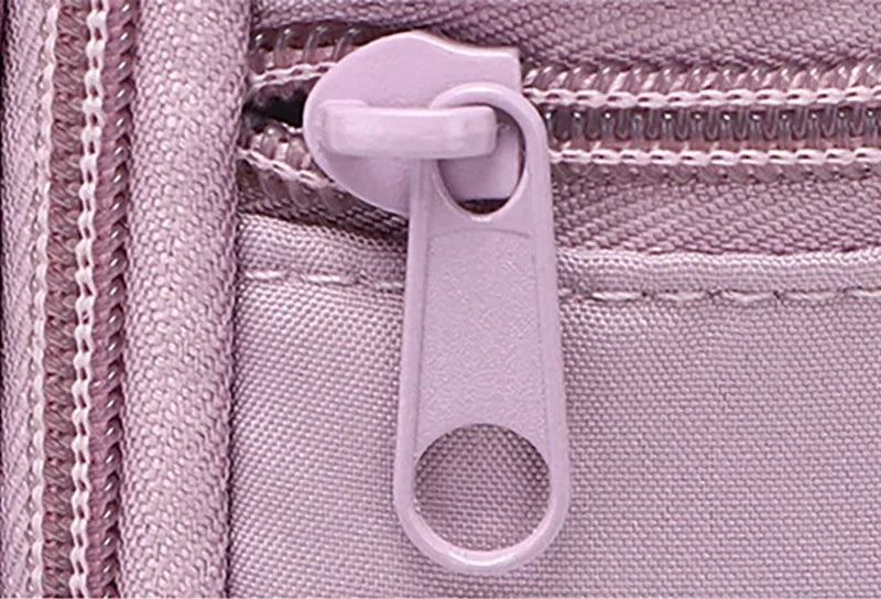 Extreme close-up of CarrySling zipper pull on light purple fabric, showing smooth zipper teeth