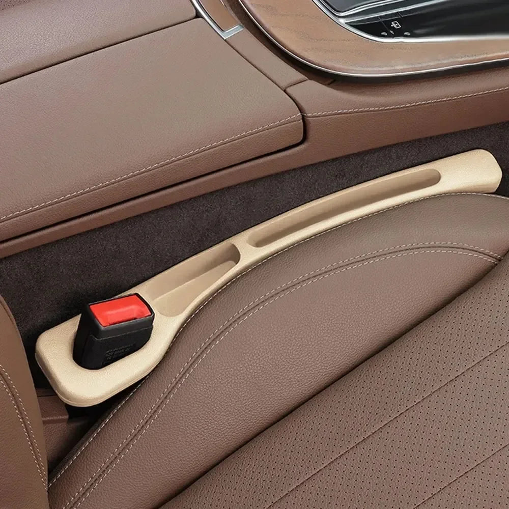 GapGuard beige seat gap filler installed in tan leather car seat, close-up of red seatbelt buckle